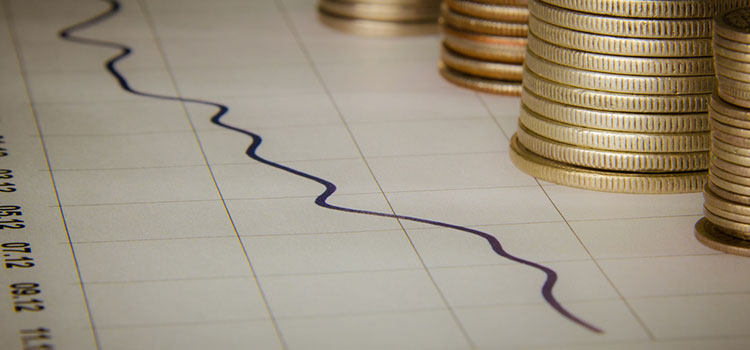 Gold coins in stacks next to a line graph.