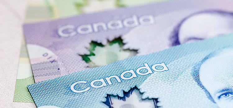 Canadian dollar bills stacked on top of each other.