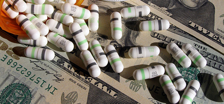 Prescription pharmaceuticals and $20 bills, USD.