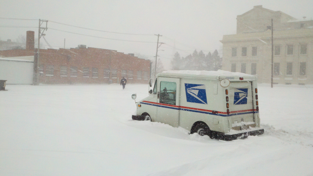 Mail delivery man stuck in snow.,