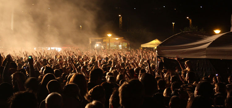 Excited crowd at an outdoor hip hop music concert.