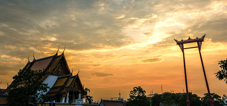Sunset in Bangkok outside the Buddhist temple Wat Suthat.