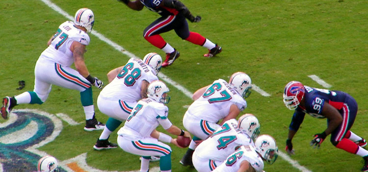 Two NFL teams clash on the field during a pro football game.