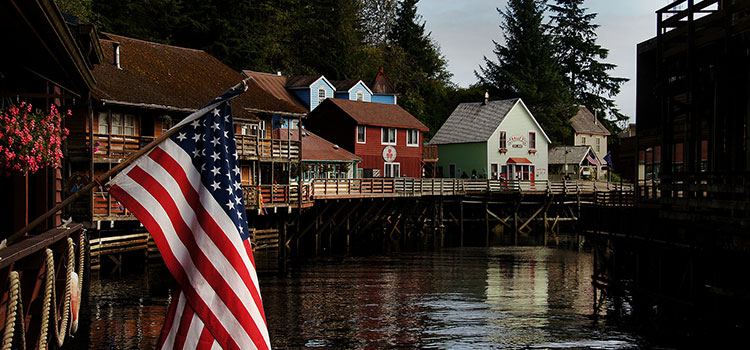 The U.S. flag and Creek Street, in Ketchikan, Alaska