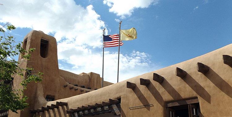 Flags flying on top of an adobe-style building in Santa Fe, New Mexico.