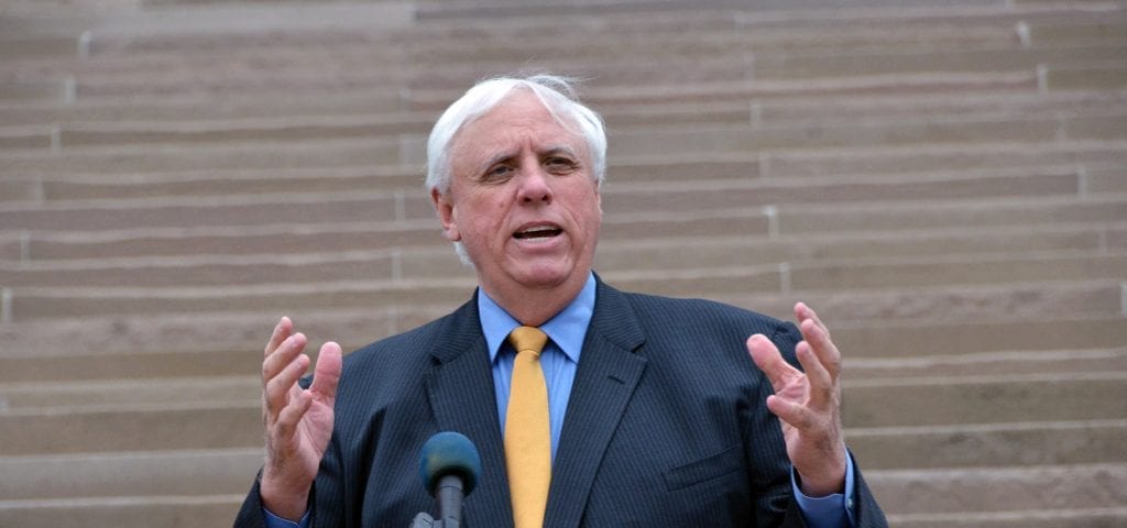 West Virginia's Governor Jim Justice giving a speech on the steps of the state capitol building.