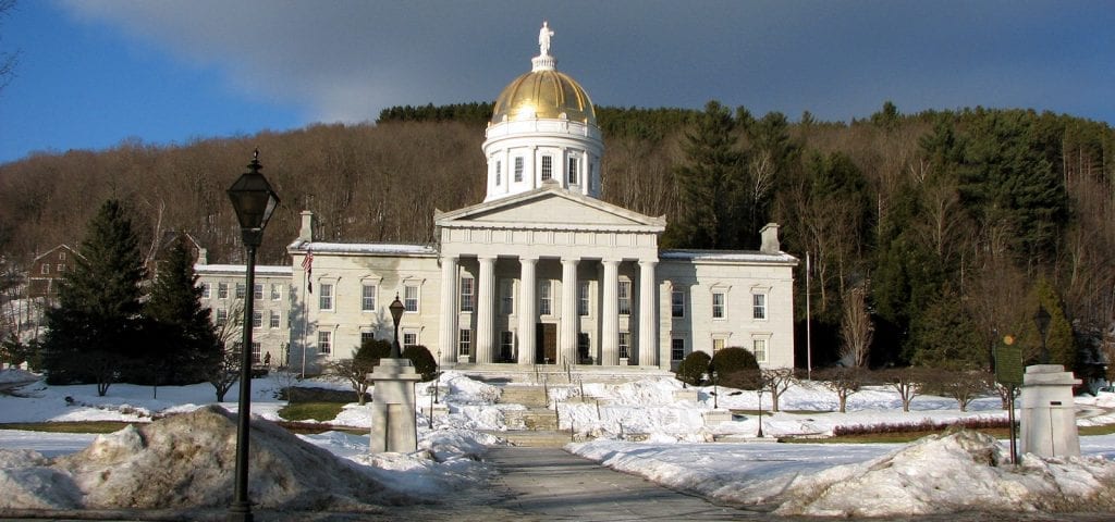 The Vermont capitol building surrounded by snow on a sunny, winter day.
