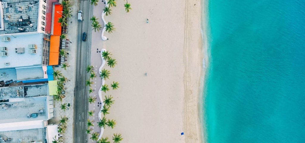 A top-down view of the beach and a nearby road in the Cayman Islands.