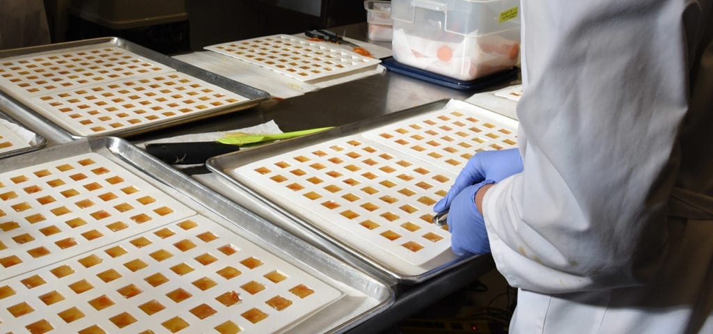 A cannabis worker packages concentrate products for consumption in Washington state.