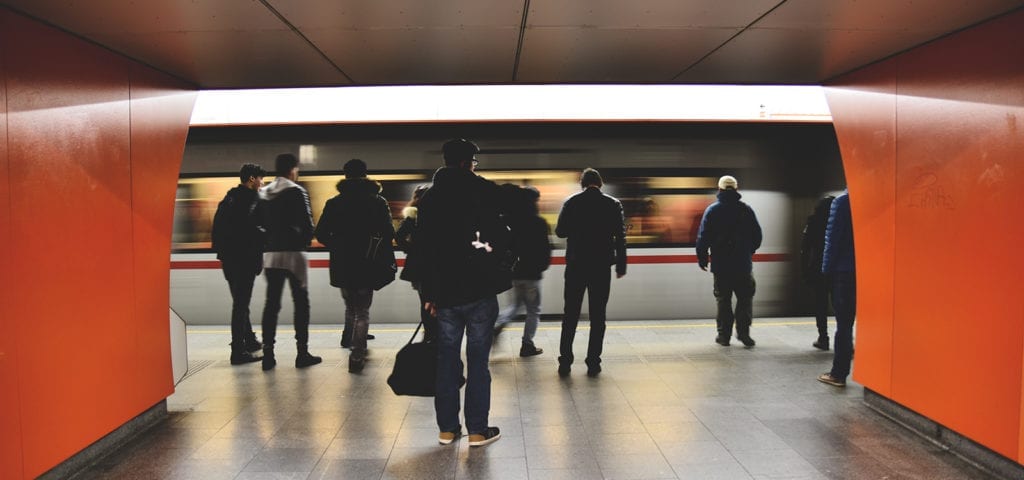 Train riders wait for the subway to come to a stop before boarding.