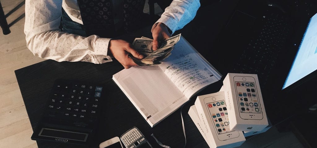 A business person counts cash as part of their taxpaying procedures.