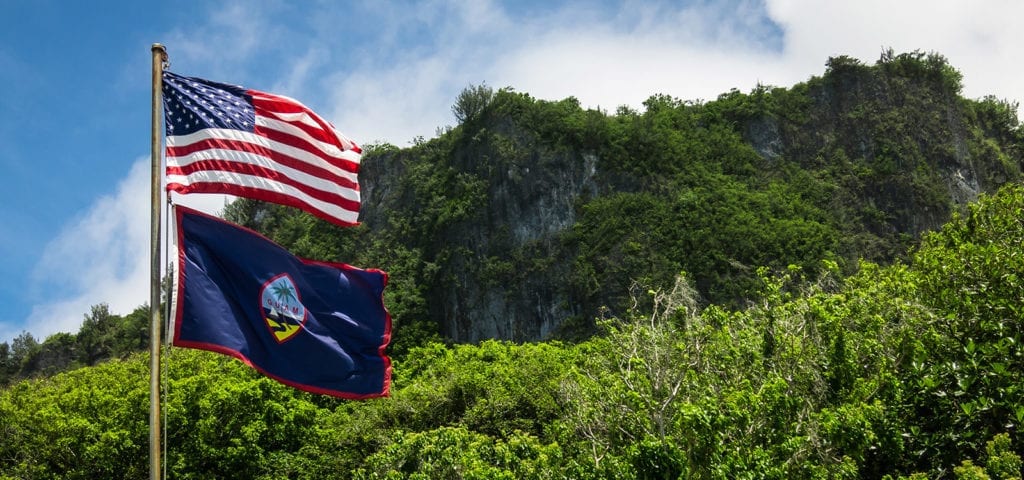 The Guam and U.S. flags pictured at Ritidian Point in the Guam National Wildlife Refuge.
