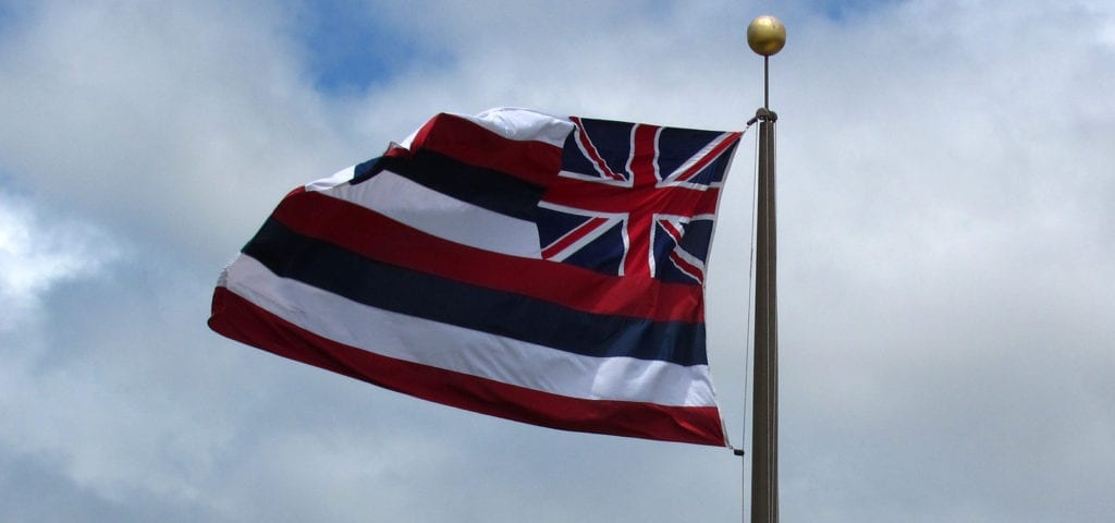 The flag of Hawaii flying above the bay in Honolulu, Hawaii.