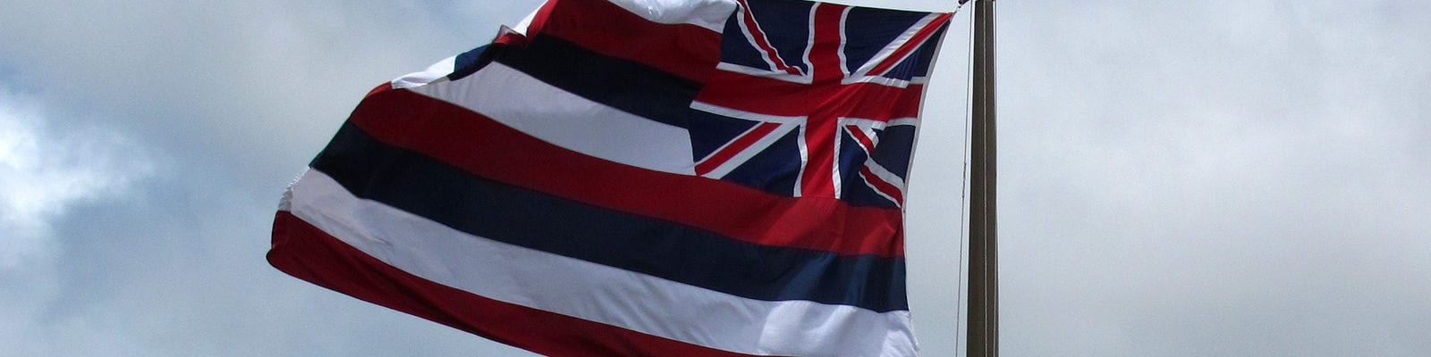 The flag of Hawaii flying above the bay in Honolulu, Hawaii.