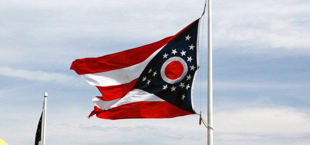 The Ohio state flag flapping on a windy day in the state's capital city.