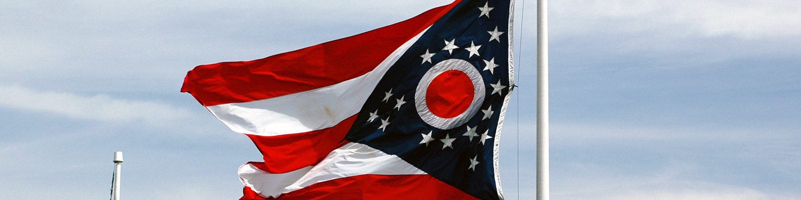 The Ohio state flag flapping on a windy day in the state's capital city.