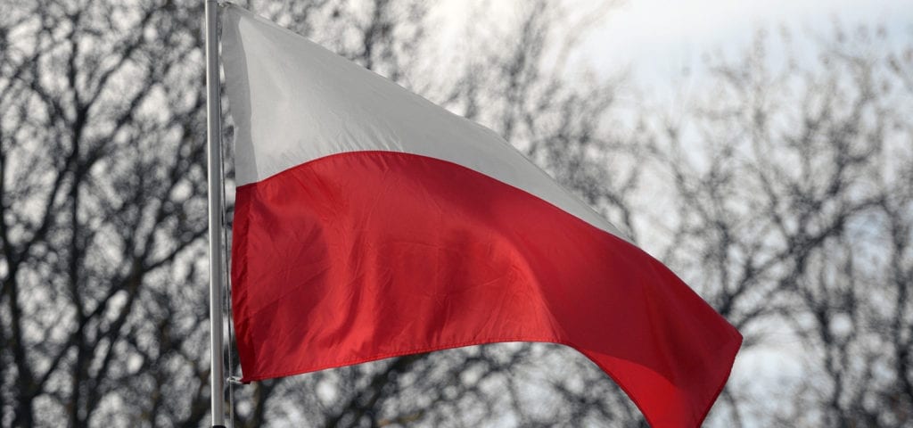 The flag of Poland flying on a windy, cloudy day.