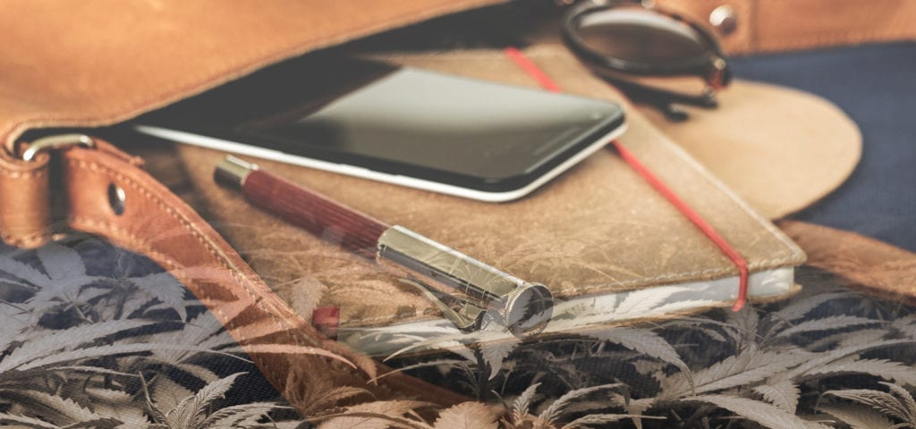 A leather notepad, pen, and cell phone -- the early tools in an entrepreneurial journey.