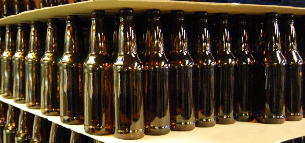 Rows upon rows of bottles inside of a micro brewery.