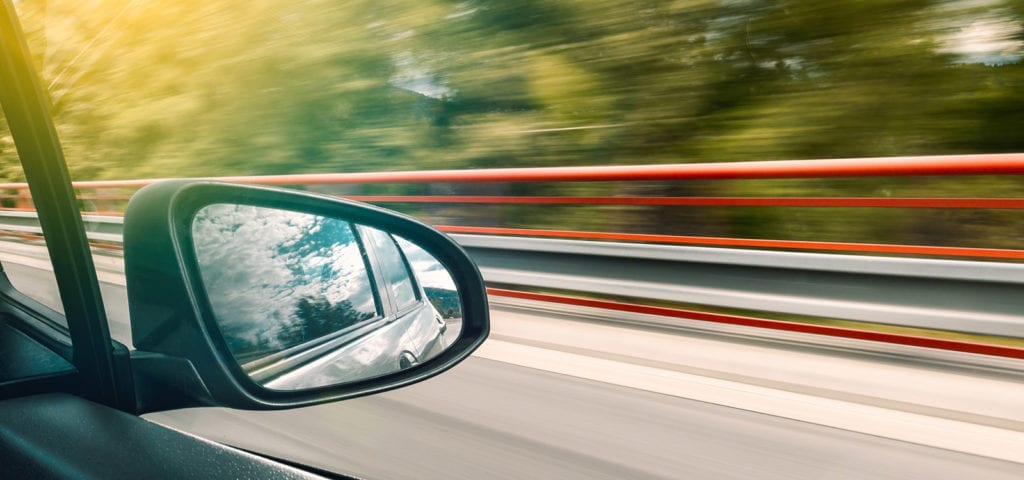 Looking out the passenger window of a moving car.