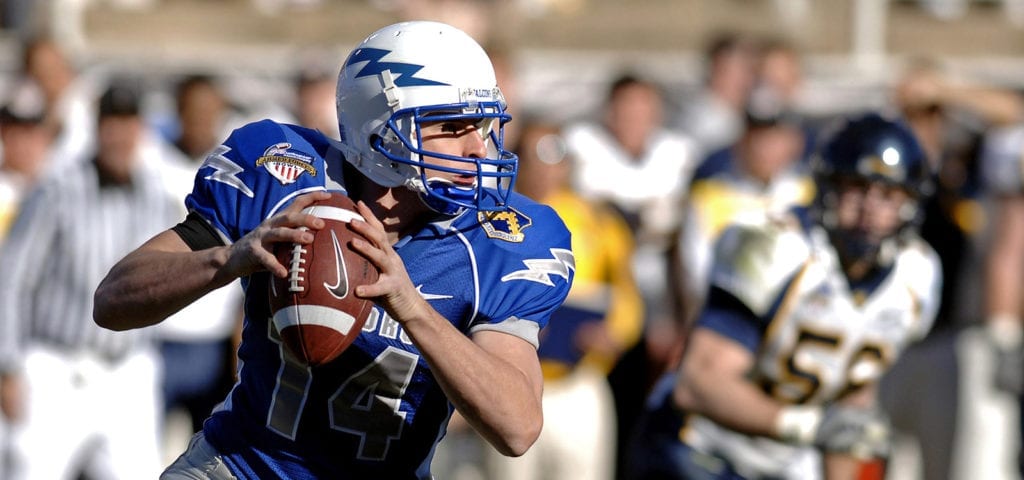 A NFL quarterback looks down field to make a pass.