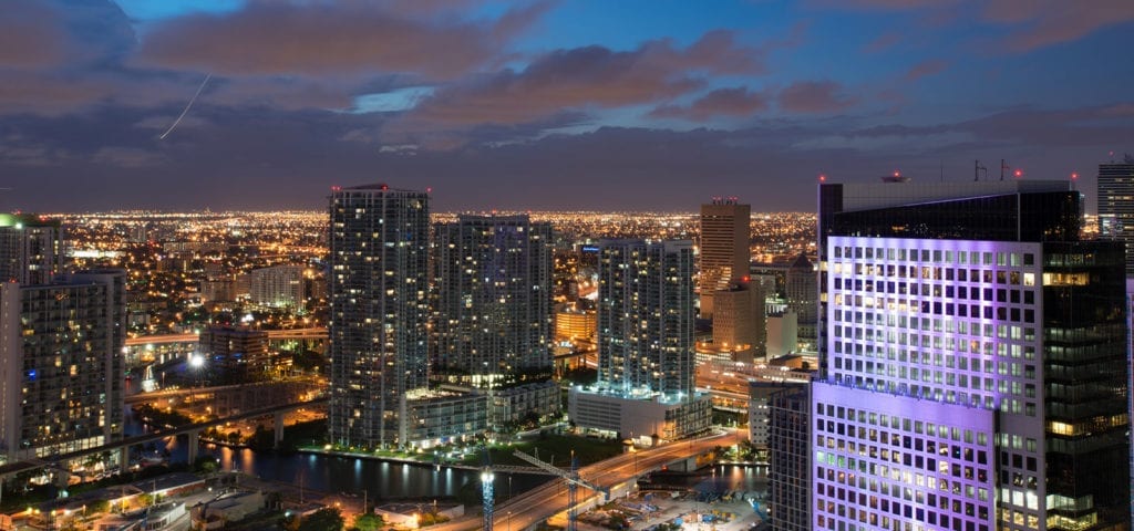 A nighttime photo of the Miami city skyline.