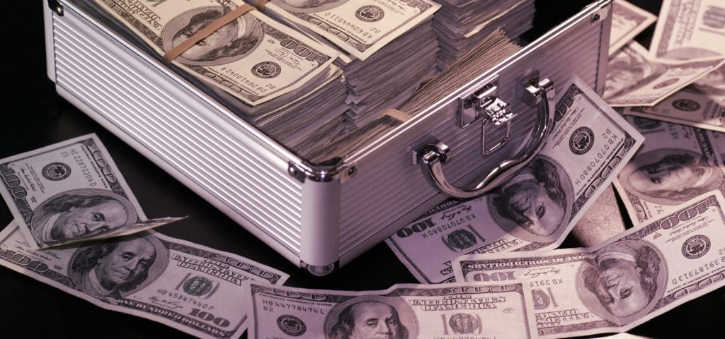 A small suitcase case stuffed with $100 bills in U.S. dollars.