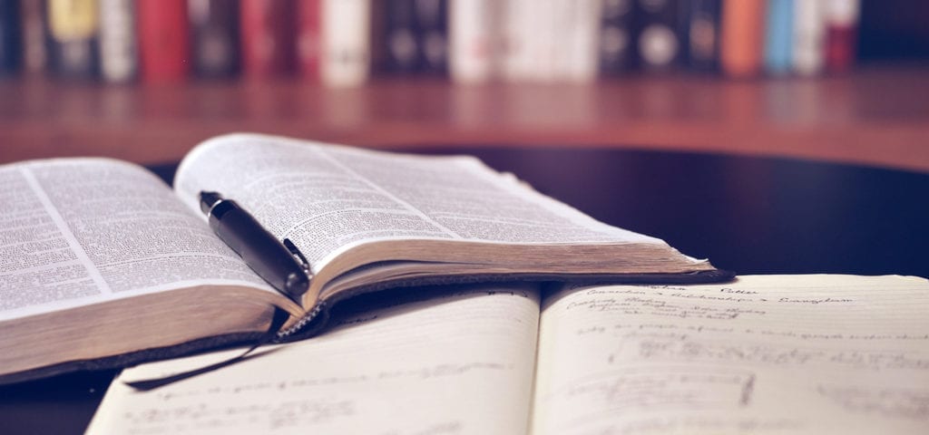 Legal texts sitting open on a dark wood table.