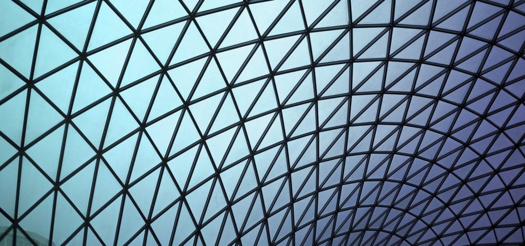 Tinted blue and purple windows of a curved, glass roof.