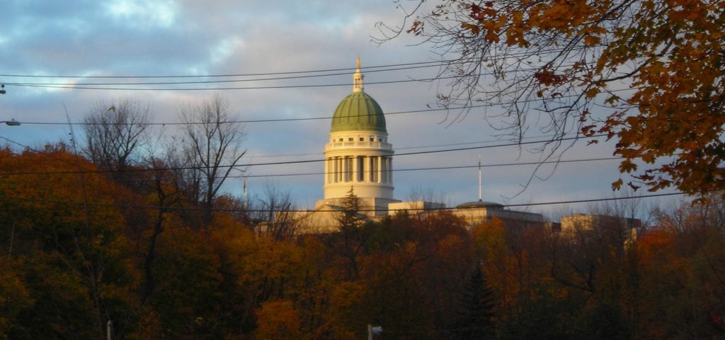 View of the Maine Statehouse in Augusta, Maine with autumn colors in the trees.