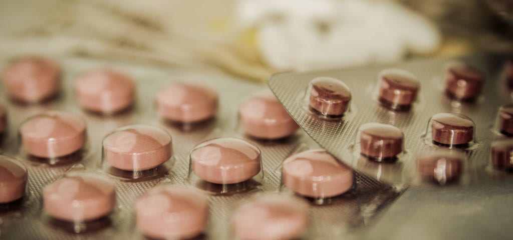 Pharmaceutical medications wrapped in plastic and foil on a flat surface.