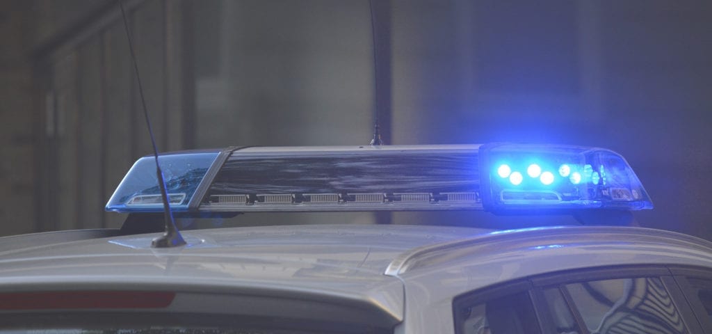 Blue police lights on top of a white cruiser.