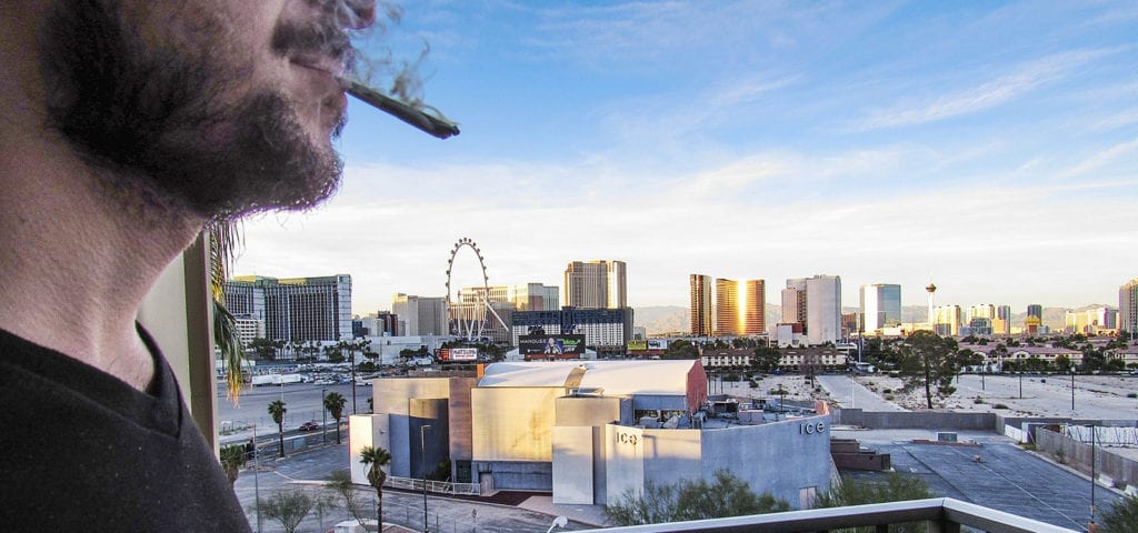 A man smoking a joint on a hotel balcony just outside of the Las Vegas strip.