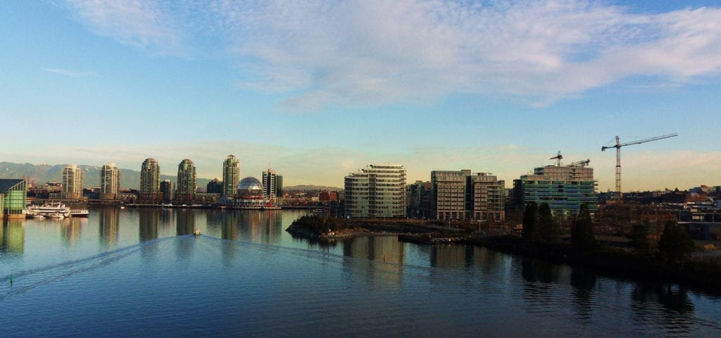 A small boat sails into the harbor of Vancouver, British Columbia, Canada.