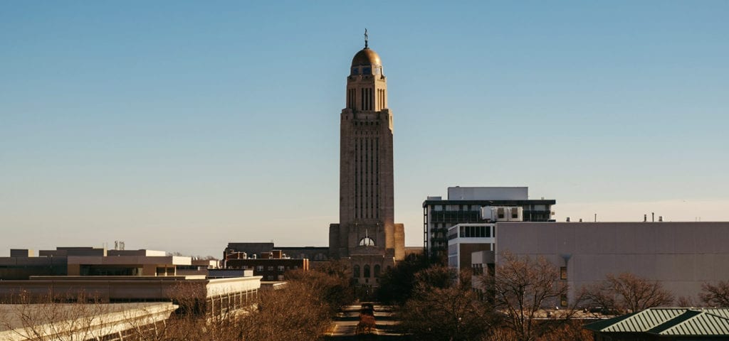 Photo taken looking down the street at the Nebraska State Capitol Building.