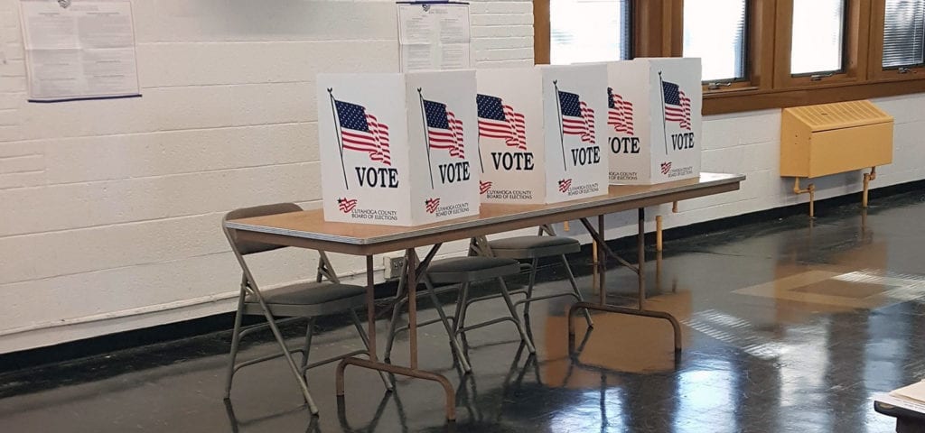 Voting booths set up temporarily in a school gymnasium.