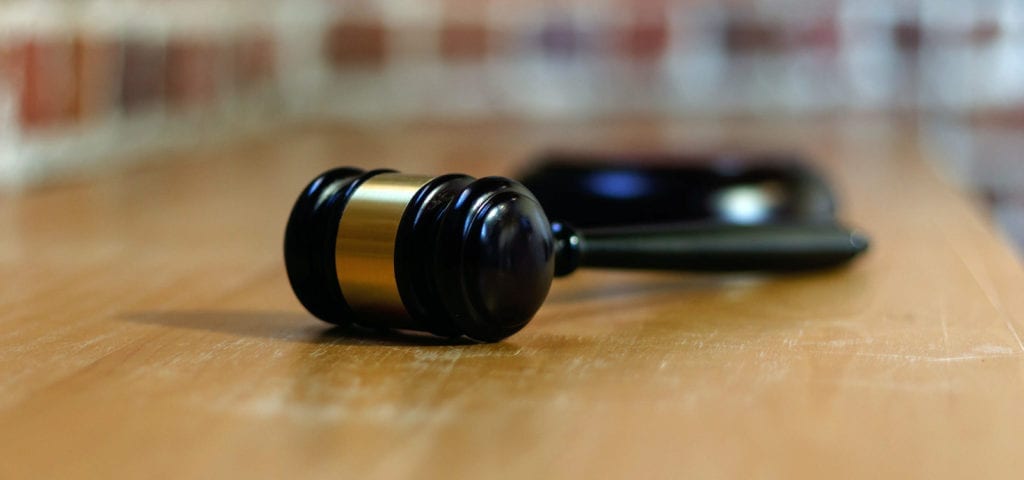 Photo of a judge's gavel lying on its side on a wooden surface.