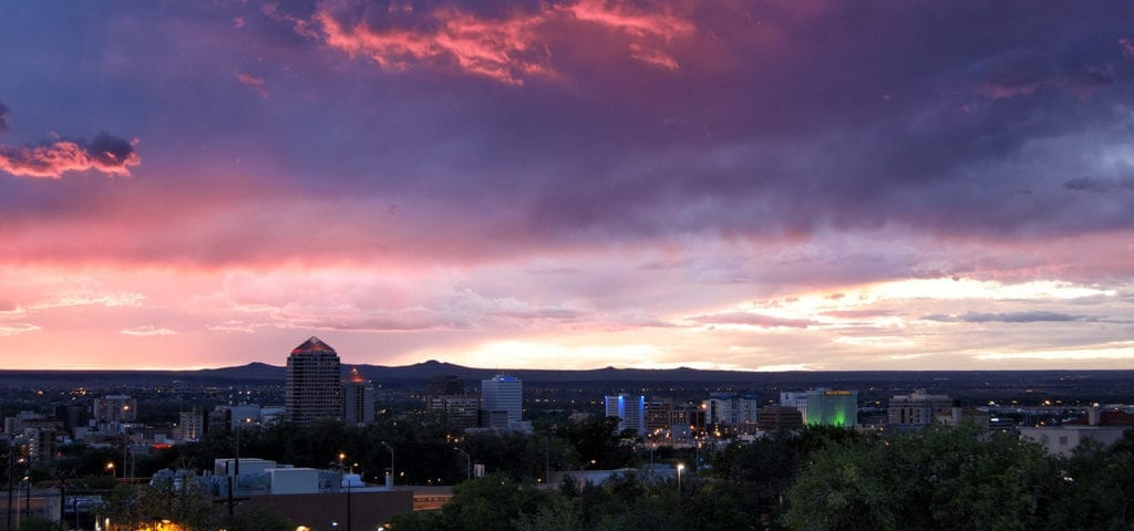 The Albuquerque skyline, photographed at sunset during a purple and blue hued sunset.
