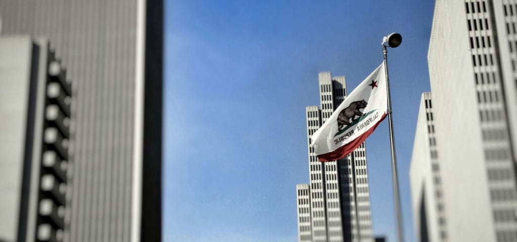 The California state flag flies high among several skyscrapers in San Francisco, California.