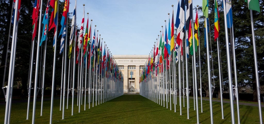 Photograph of the view looking down the row of flags at the United Nations office in Geneva.