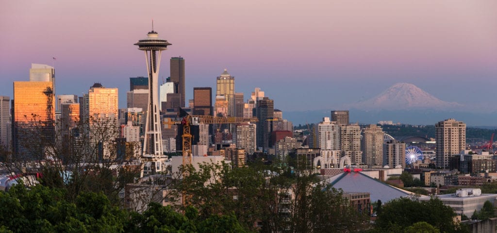 Photograph of a sunset view of Seattle, Washington with Mount Rainier in the background.