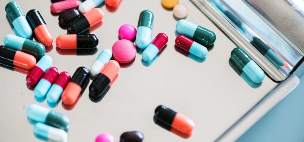 Assorted pharmaceutical medicines scattered on a tray.