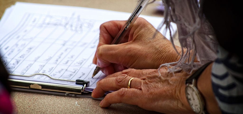 A woman signs a petition circulating through her neighborhood.