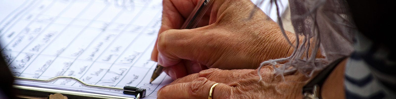 A woman signs a petition circulating through her neighborhood.